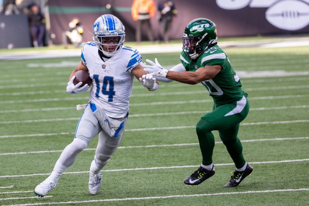 Michael Carter II of the Jets covers Lions wide receiver Amon-Ra St.  Brown