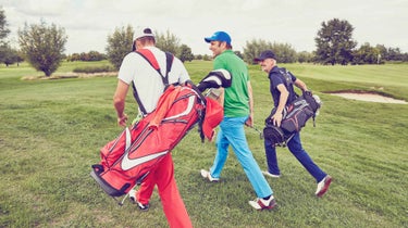 Three men walking on a golf course