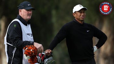 Tiger Woods of the United States and caddy Joe LaCava wait to play a putt on the 17th hole during the second round of The Genesis Invitational at Riviera Country Club on February 17, 2023 in Pacific Palisades, California.