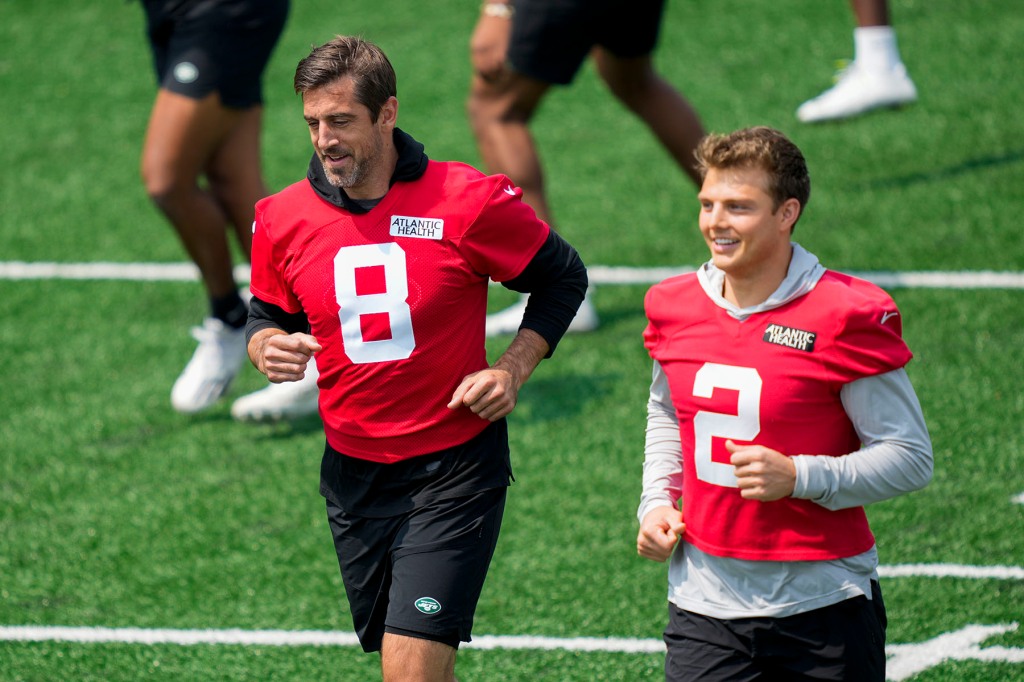 New York Jets quarterback Aaron Rodgers (8) performs stretching exercises with quarterback Zack Wilson (2) at the NFL football team's training facility, Tuesday, May 23, 2023, in Florham Park, NJ 