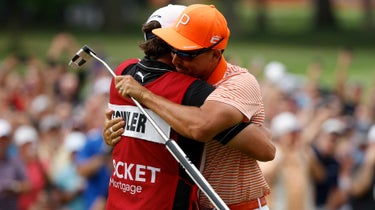 Ricky Fowler of the United States celebrates his caddy, Ricky Romano, on the 18th green after winning his first-round playoff during the final round of the Rocket Mortgage Classic at Detroit Golf Club on July 02, 2023 in Detroit, Michigan.