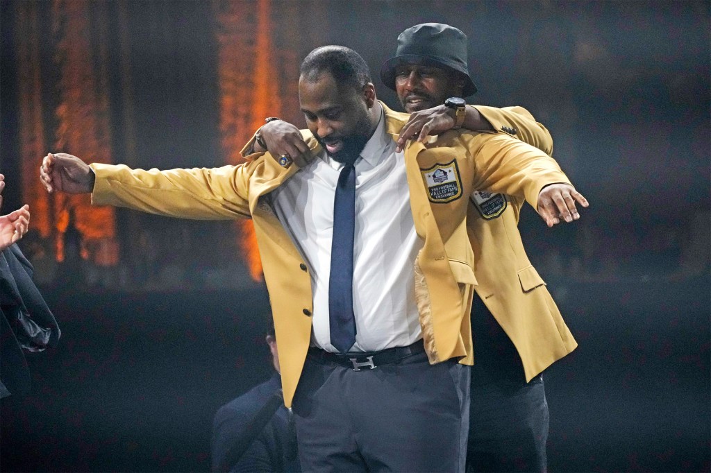 Darrelle Revis gets his gold jacket Friday night in Canton, Ohio.