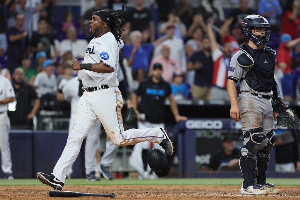 Josh Bell crosses home plate with the game-tying run in the Marlins' win over the Yankees.