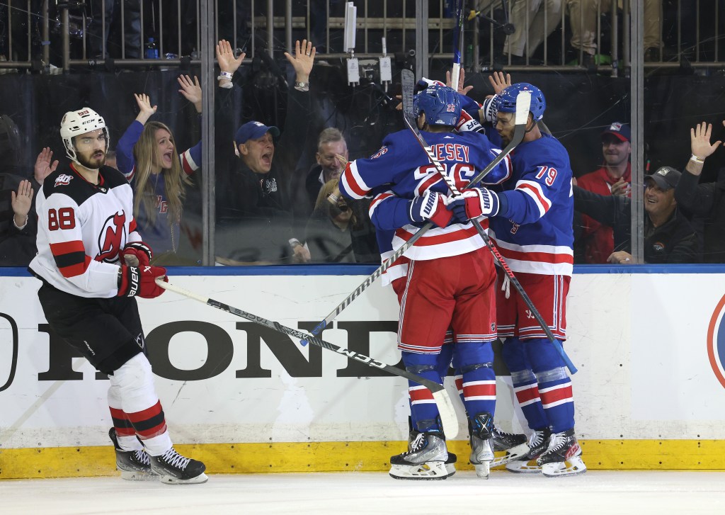 Barclay Goodrow celebrates his goal with Rangers teammates as the Devils' Kevin Bahl skates away.
