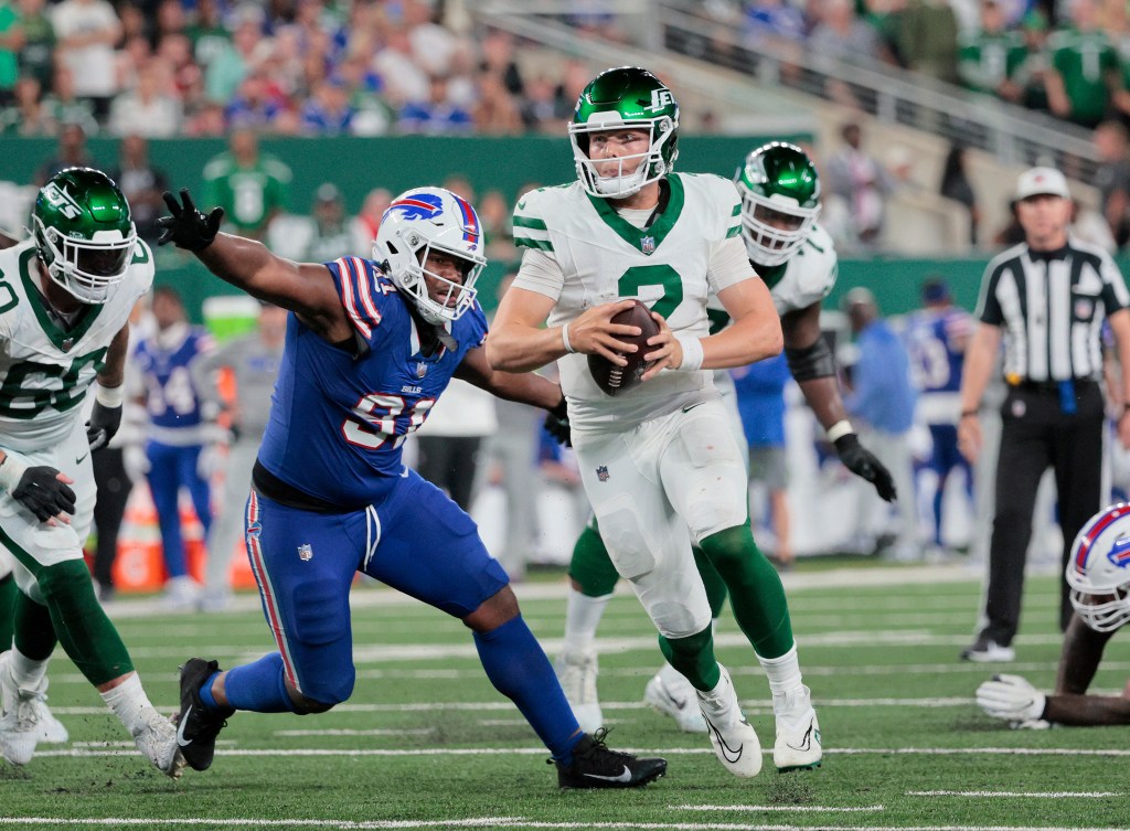 Jets quarterback Zach Wilson #2 runs out of the pocket as Buffalo Bills defensive tackle Ed Oliver #91 rushes