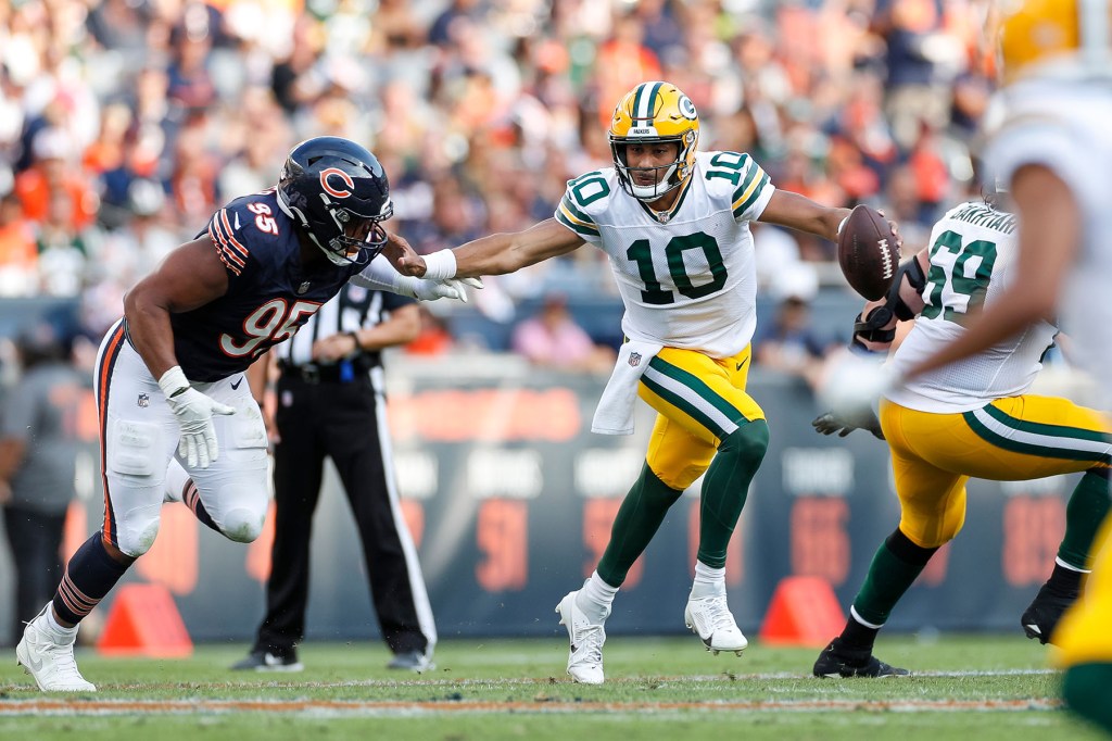 Green Bay Packers quarterback Jordan Love (10) scrambles under pressure from Chicago Bears defensive end DeMarcus Walker (95) in the second half during a regular season game between the Green Bay Packers and the Chicago Bears on September, 10, 2023, at Soldier Field in Chicago, IL.