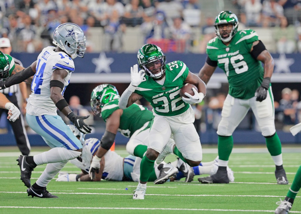 The Jets' Michael Carter runs the ball against the Cowboys.